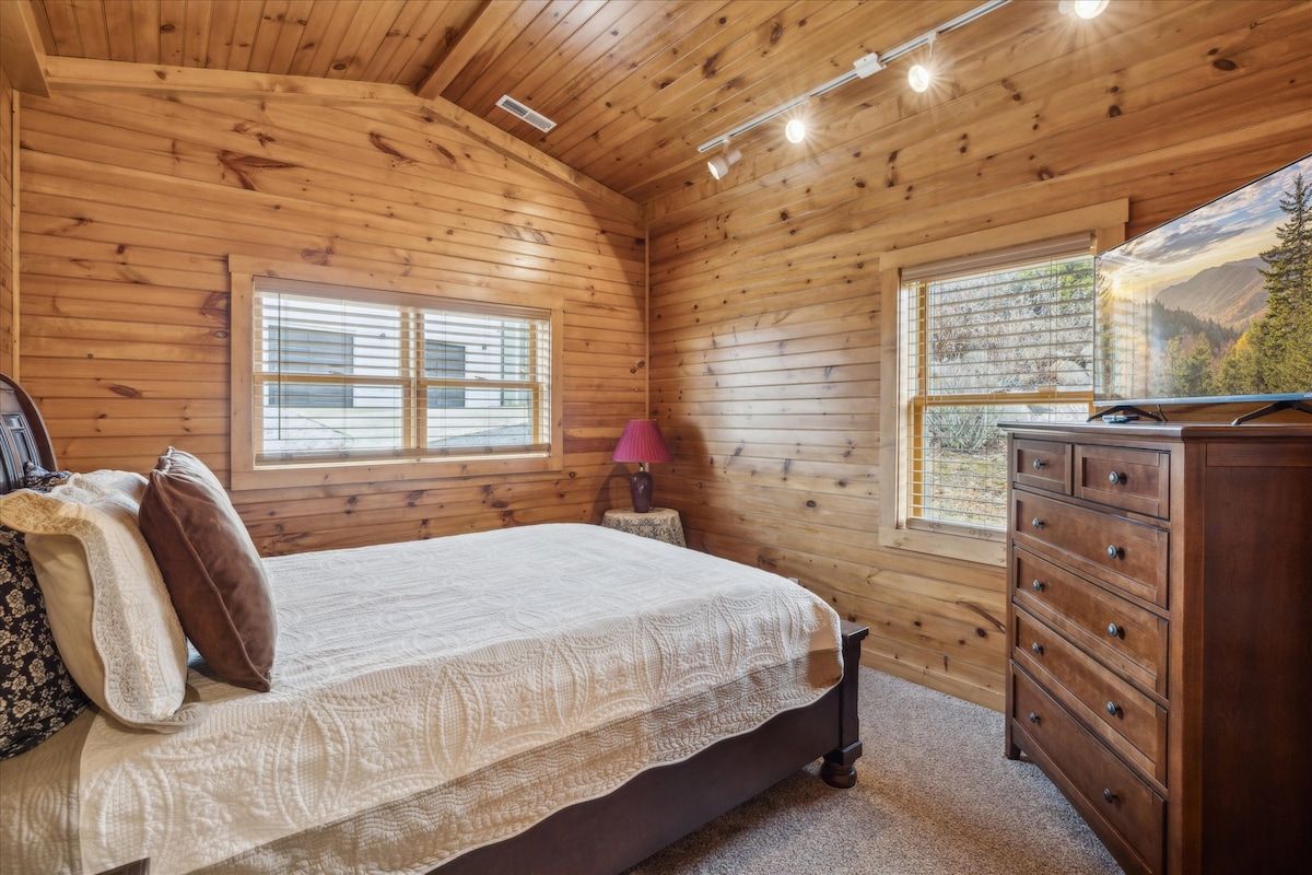 Primary Bedroom Retreat: Relax in rustic charm with mountain views and warm wood accents!