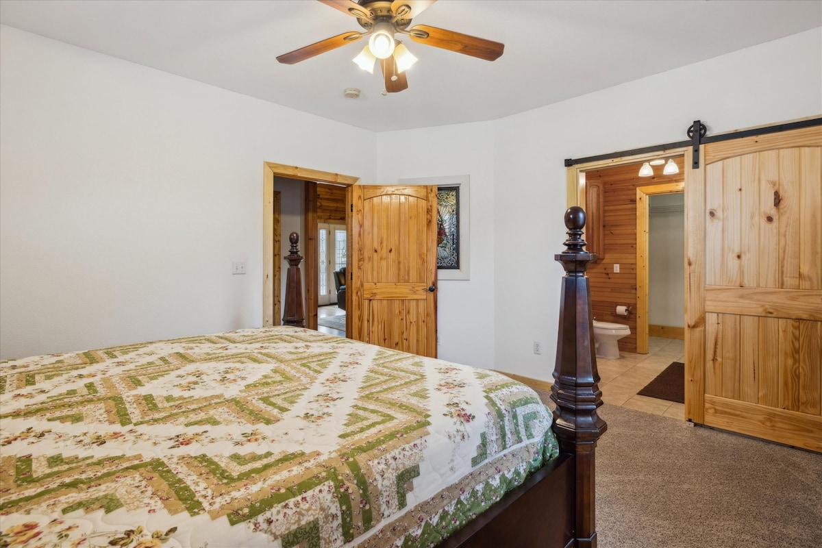 Enjoy rustic charm with a beautiful quilt and stunning wood accents in the king primary suite, with ensuite.