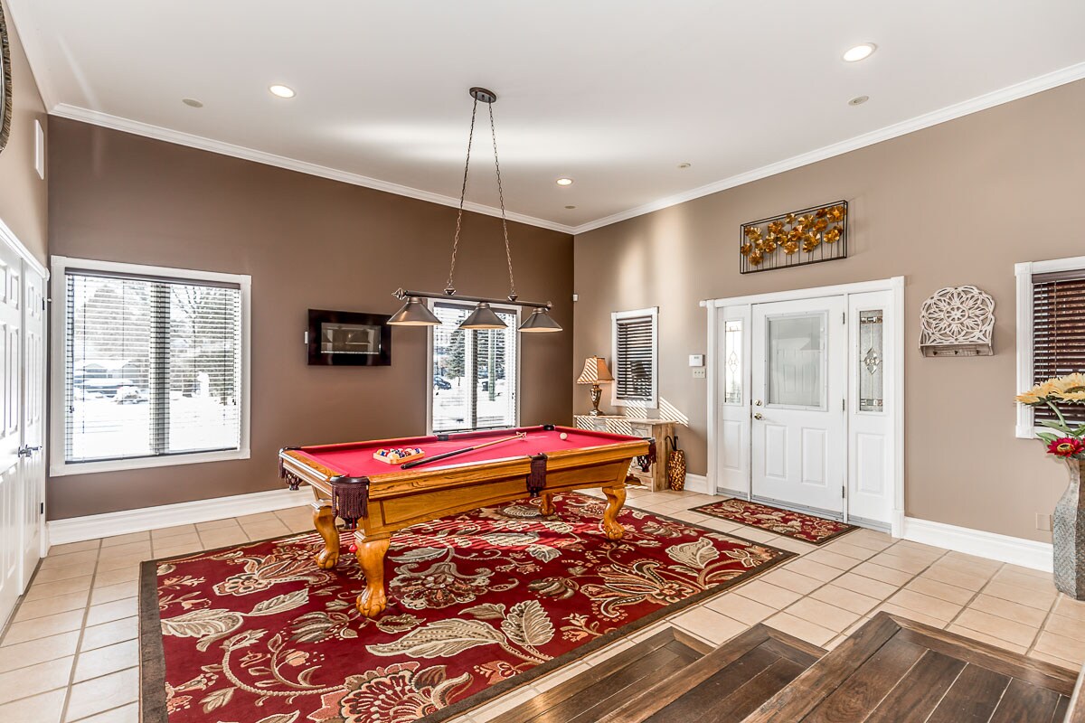 First-floor pool room with direct access to the lobby between the house and garage. Large west-facing windows offer a bright view of the street. 