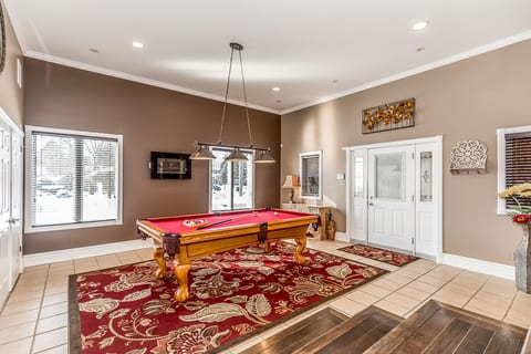 First-floor pool room with direct access to the lobby between the house and garage. Large west-facing windows offer a bright view of the street.