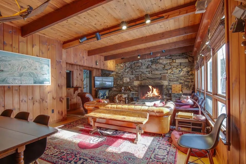 Living room is equipped with large handmade Chesterfield leather sofa, two vintage leather club chairs and vintage leather recliner. An exceptionally large wood-burning fireplace flanked by antique ski equipment adds warmth for cold Vermont nights.