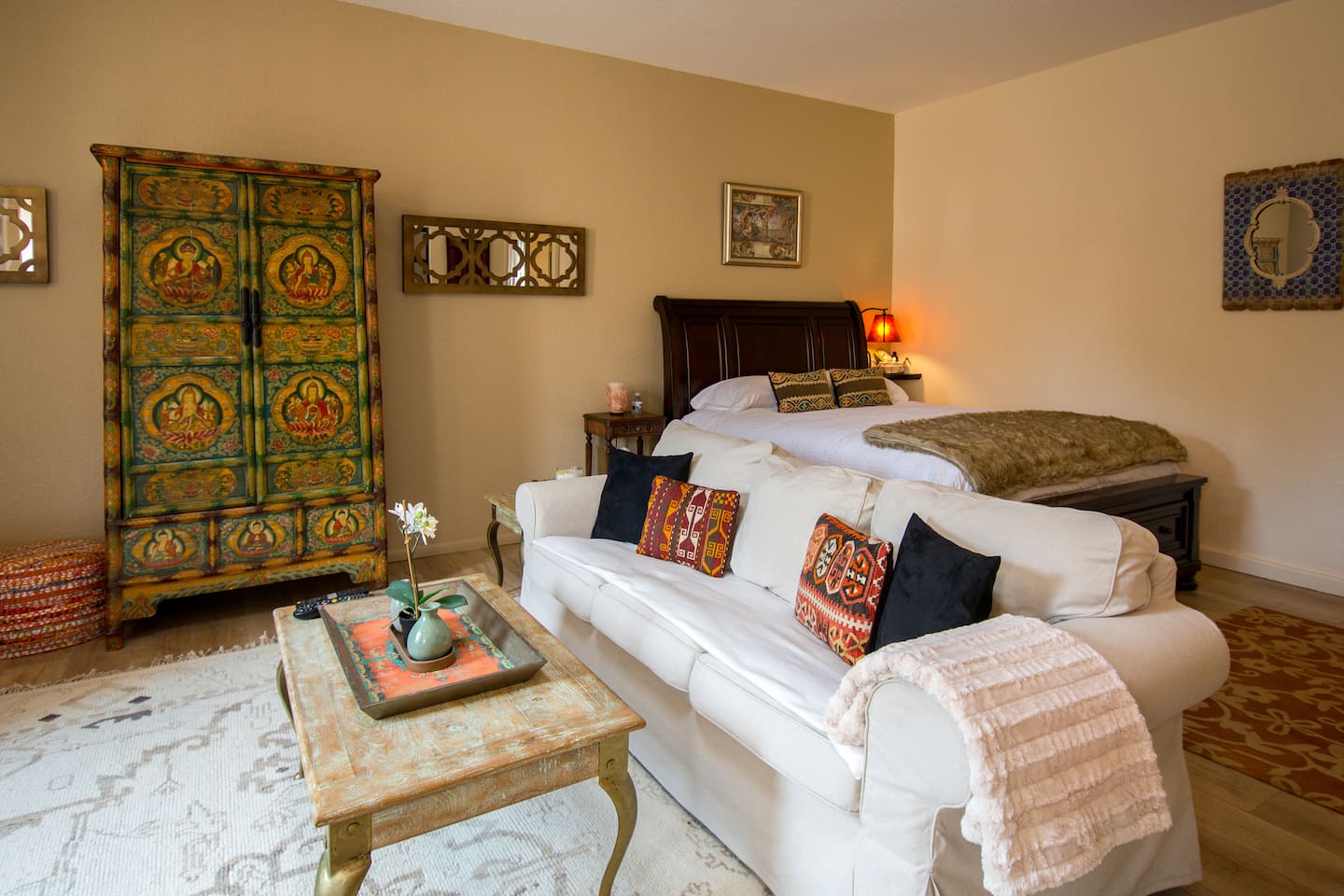 Main living area with Tibetan armoire, sitting area, and queen sized bed