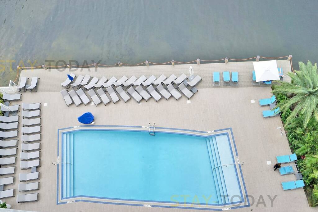 Bird's-eye view of the pool area, showcasing plenty of pool chairs for your relaxation. With ample seating, it's the perfect place to enjoy the sun and unwind by the water.