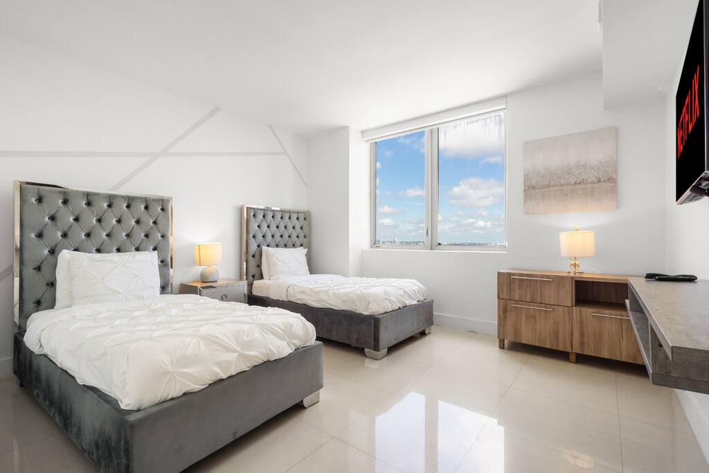 Step into a bright bedroom featuring two comfortable single beds and modern décor. With its own in-room bathroom, it’s perfect for convenience and relaxation.