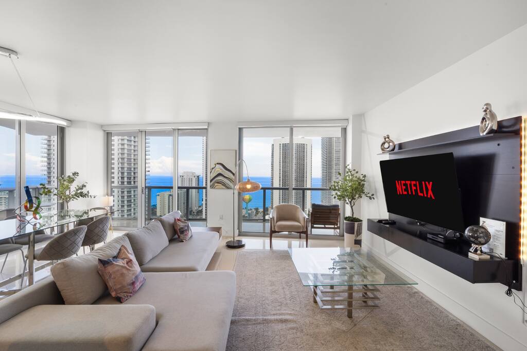 Step into a welcoming space where luxury meets relaxation. Enjoy the 58-inch Smart TV, relax on the plush couch, or gather at the dining table - all while surrounded by floor-to-ceiling views of the ocean and city.