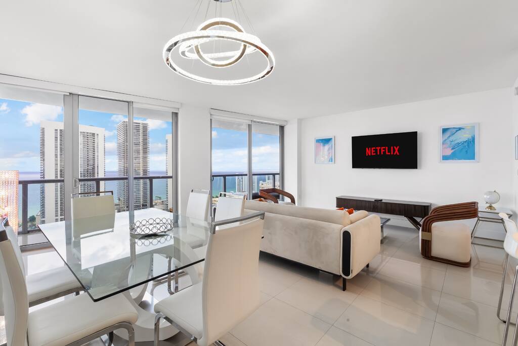 Gather at the elegant glass dining table with space for six, just steps from the living area and surrounded by panoramic ocean and city views.