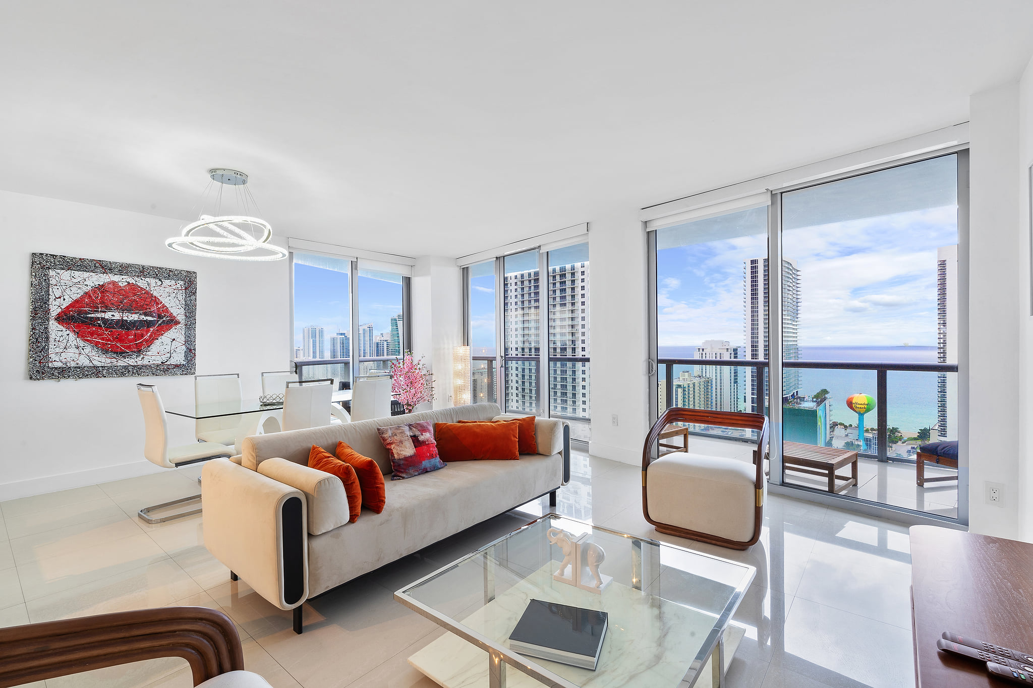 Corner condo with ocean and skyline views, balcony, and chic modern decor.