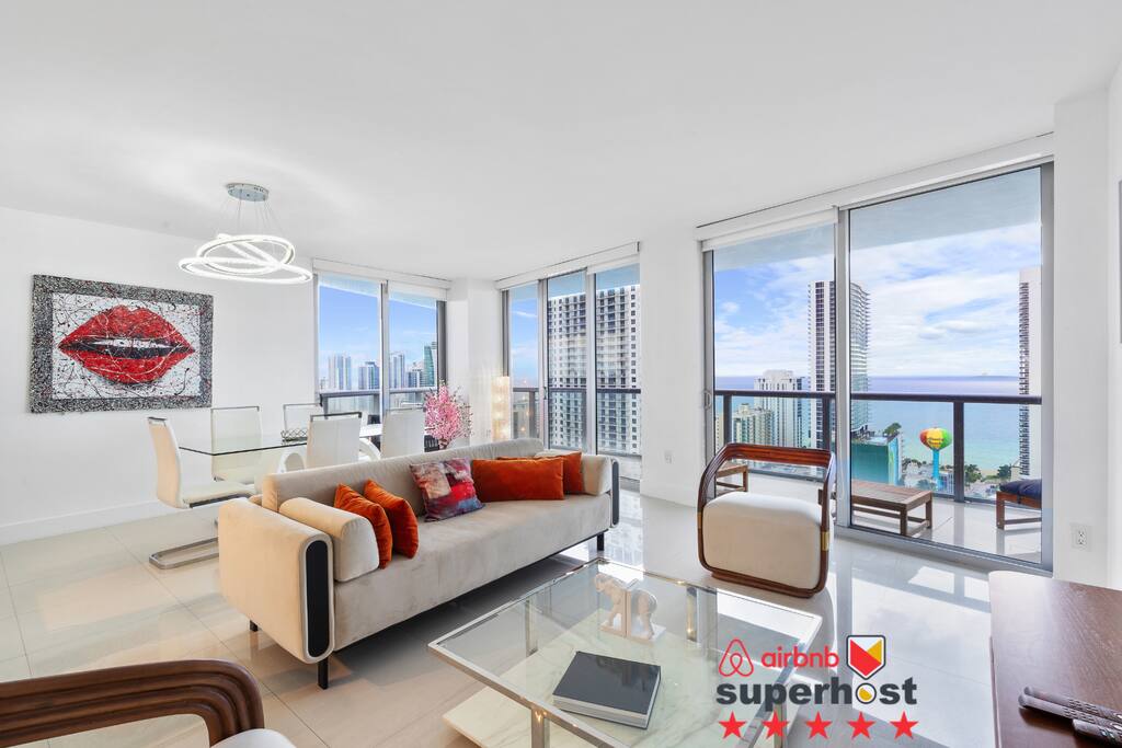 Step into a bright living space filled with natural light, bold accents, and panoramic views of the ocean and city skyline. A perfect blend of comfort and contemporary style.