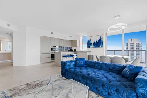 Wake up to breathtaking views of the sparkling ocean and vibrant cityscape through expansive floor-to-ceiling windows. The spacious living area flows seamlessly into the modern kitchen, making it a perfect spot to relax or entertain.