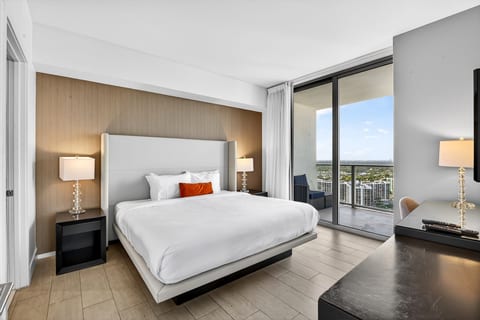 Modern king suite with private balcony and sweeping skyline views