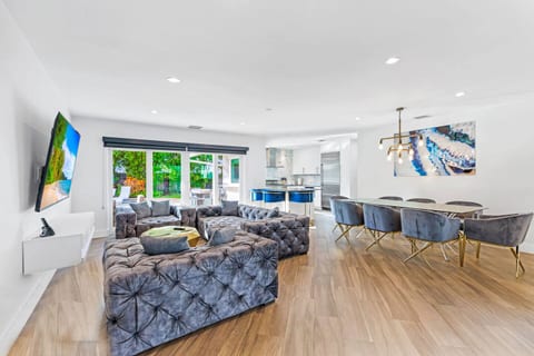 The open-concept design flows effortlessly from the living area to the dining space and kitchen. Enjoy meals at the stylish dining table or gather around the kitchen island with vibrant seating, all overlooking the serene backyard.