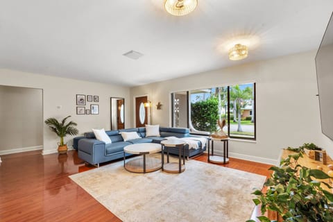 With clean lines, a modern sectional, and soft accents, the living room blends style and comfort. Bright natural light enhances the airy feel, making it a welcoming spot for relaxation.