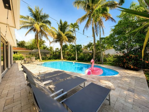 Tropical private pool retreat with loungers and sunny patio