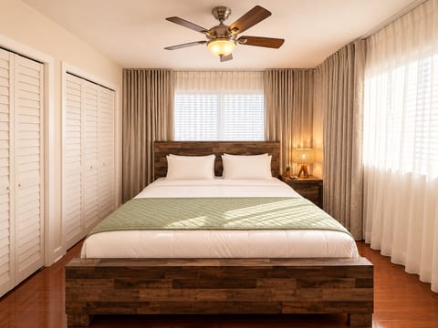 Bright king bedroom with natural light, ample closet space, and warm wood accents