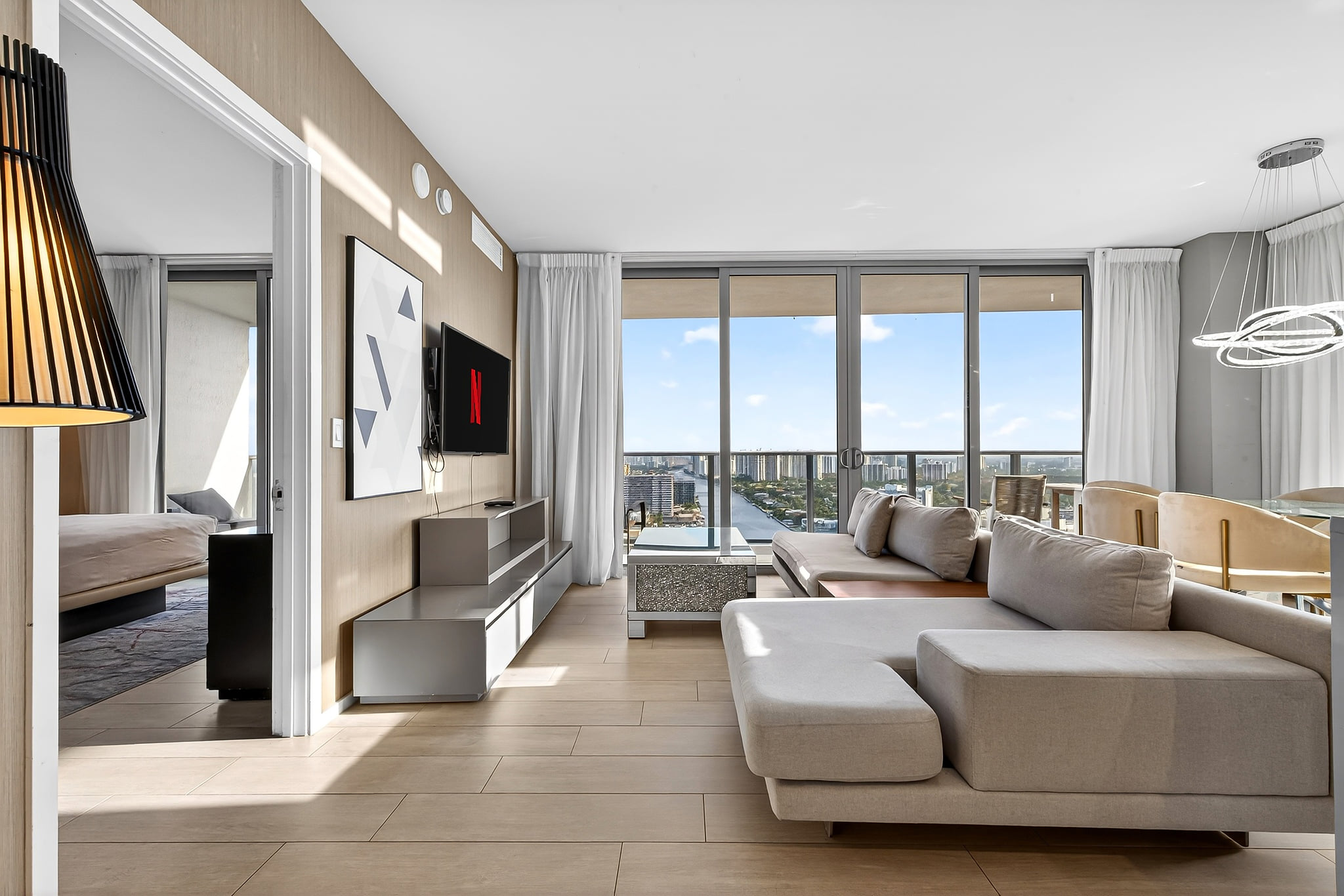 Sunny modern condo with skyline views, balcony, and chic lounge