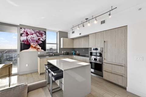 Sleek chef’s kitchen with island seating, built-ins, and skyline views
