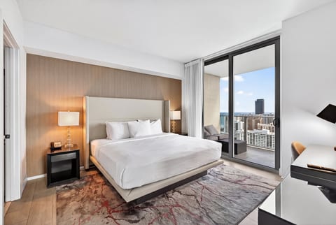 Sleek king suite with balcony, skyline views, and a handy workspace