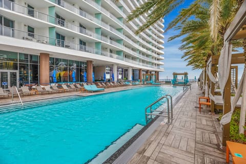 Outdoor pool surrounded by loungers and private cabanas along the deck. Located on the 9th floor, it offers a relaxing space with ocean views and easy access for all guests. Perfect for swimming or unwinding in the sun.