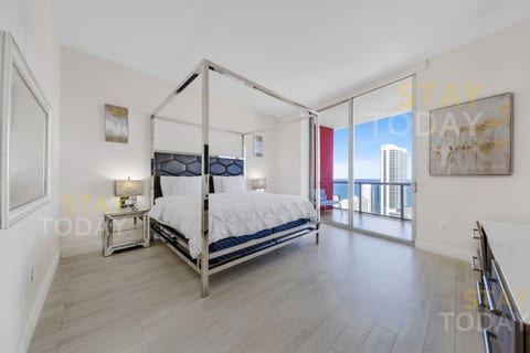 This master bedroom features a sleek king bed and a private bathroom. Spacious and modern, it boasts large glass doors with direct balcony access, filling the room with light and offering breathtaking ocean views right from your bedside.