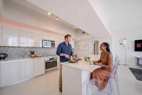 The sleek kitchen island stands out, complemented by sophisticated high chairs, perfect for casual dining or morning coffee.