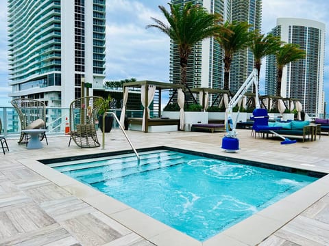 Relax in the outdoor hot tub with soothing jets and warm water. Located next to the pool and cabanas, it’s a peaceful spot to soak, unwind, and enjoy skyline views after a long day.