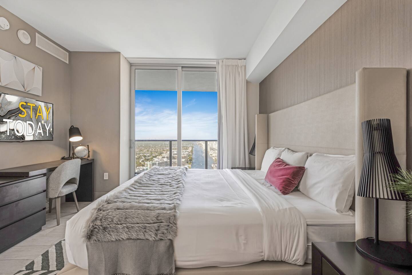 Enjoy peaceful views from this cozy master bedroom featuring a king-size bed and a dedicated workspace, perfect for relaxation or catching up on tasks during your stay.
