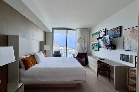 Step into a serene retreat with a plush king bed, modern décor, and floor-to-ceiling windows opening to a private balcony with city and ocean views. The en-suite bathroom also connects to the living room for added convenience.