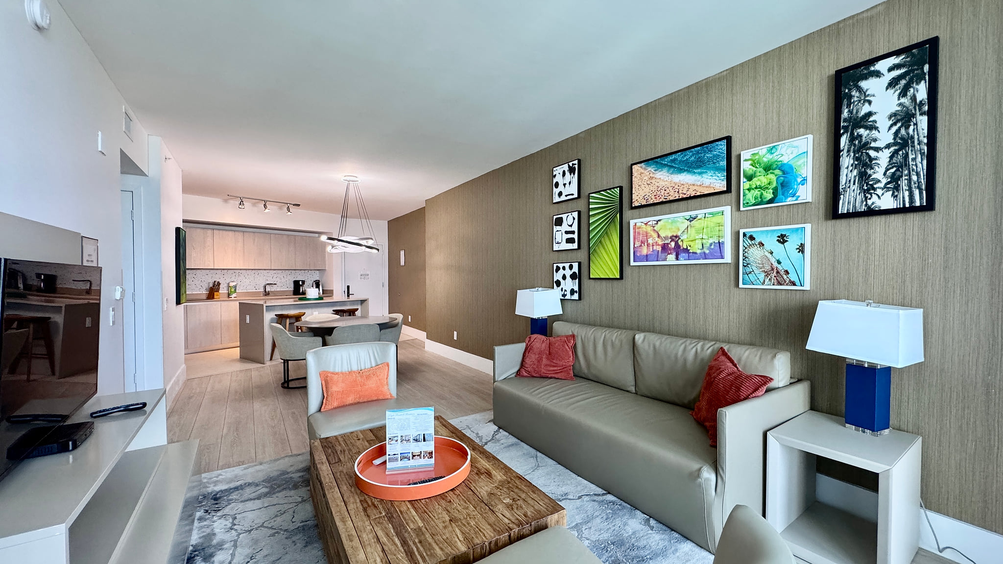 Stylish open-plan living with artful decor, cozy seating, and sleek kitchen