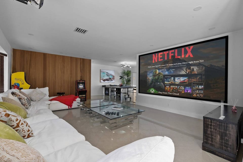 Sink into the oversized couch and enjoy movie nights on the massive projector screen. With stylish décor, a glass coffee table, and open space leading to the game area, this room is perfect for relaxing, entertaining, or gathering with friends.