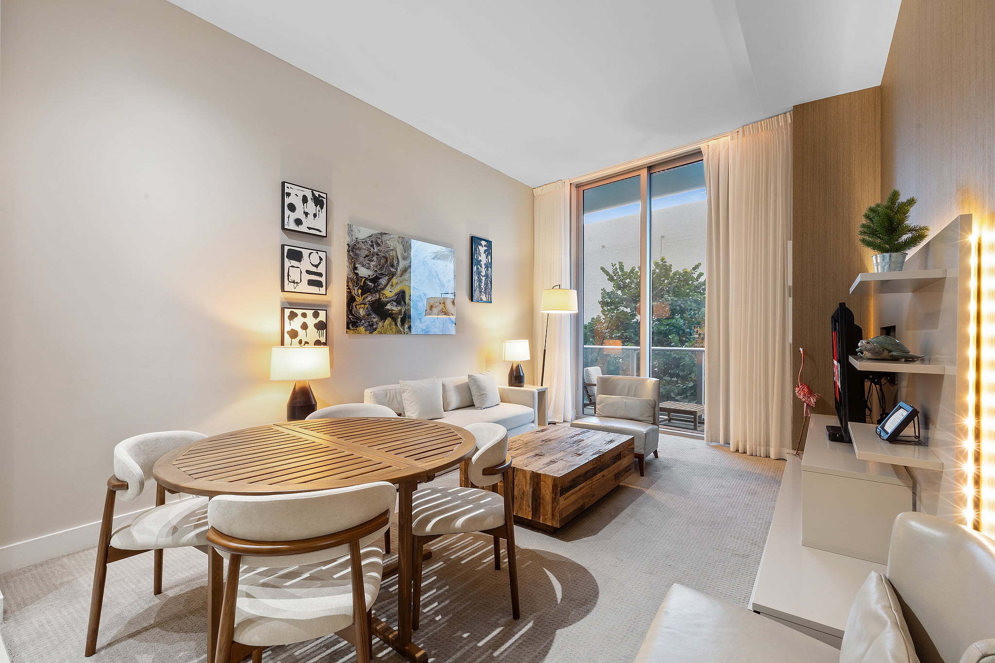 Bright living-dining space with balcony, artful décor & comfy seating