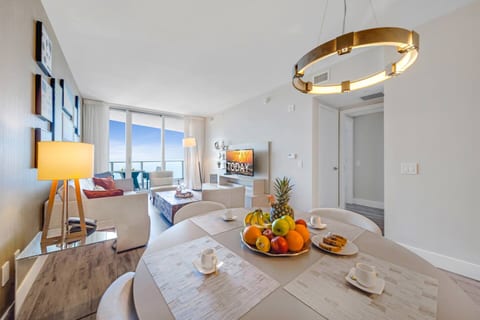 The open dining and living area offers plenty of space to enjoy meals and relax, with access to the balcony showcasing stunning ocean views.