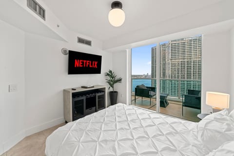 From the comfort of the bed, enjoy serene views through the balcony doors, where the skyline meets the ocean in a picture-perfect frame.