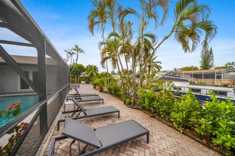 After a busy day, find your perfect spot on one of the loungers by the pool, nestled among lush greenery and palms. This serene outdoor space offers privacy and comfort as you soak up the Florida sunshine or unwind by the water.