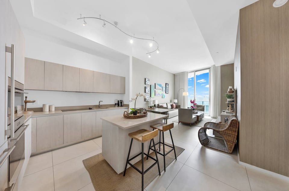 Sleek open kitchen + lounge with balcony and stunning blue-sky views