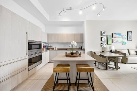This kitchen features a spacious island with seating for two, modern appliances, and ample counter space - perfect for cooking meals or enjoying a casual breakfast in a bright, open setting.