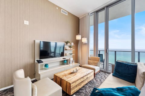 The living area is designed for relaxation, where large windows frame endless ocean views. Modern seating and a sleek coffee table set the stage for cozy conversations or a peaceful evening with your favorite show.