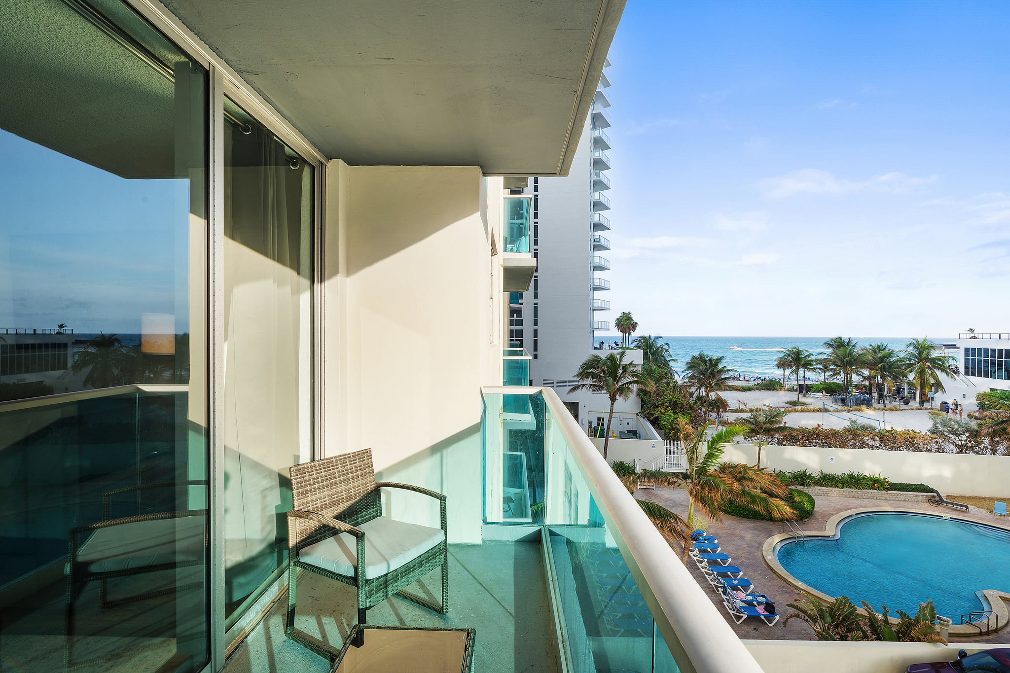 Private balcony with ocean and pool views at a beachfront resort