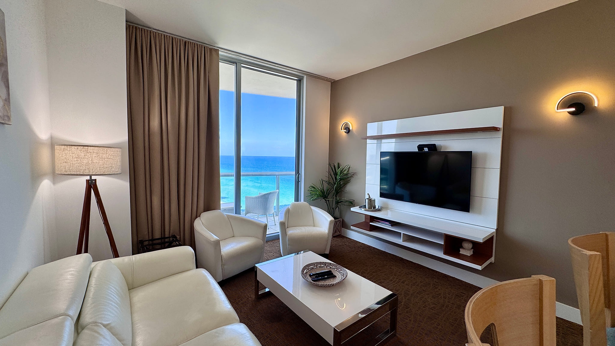 Ocean-view lounge with balcony, sleek media wall & plush seating