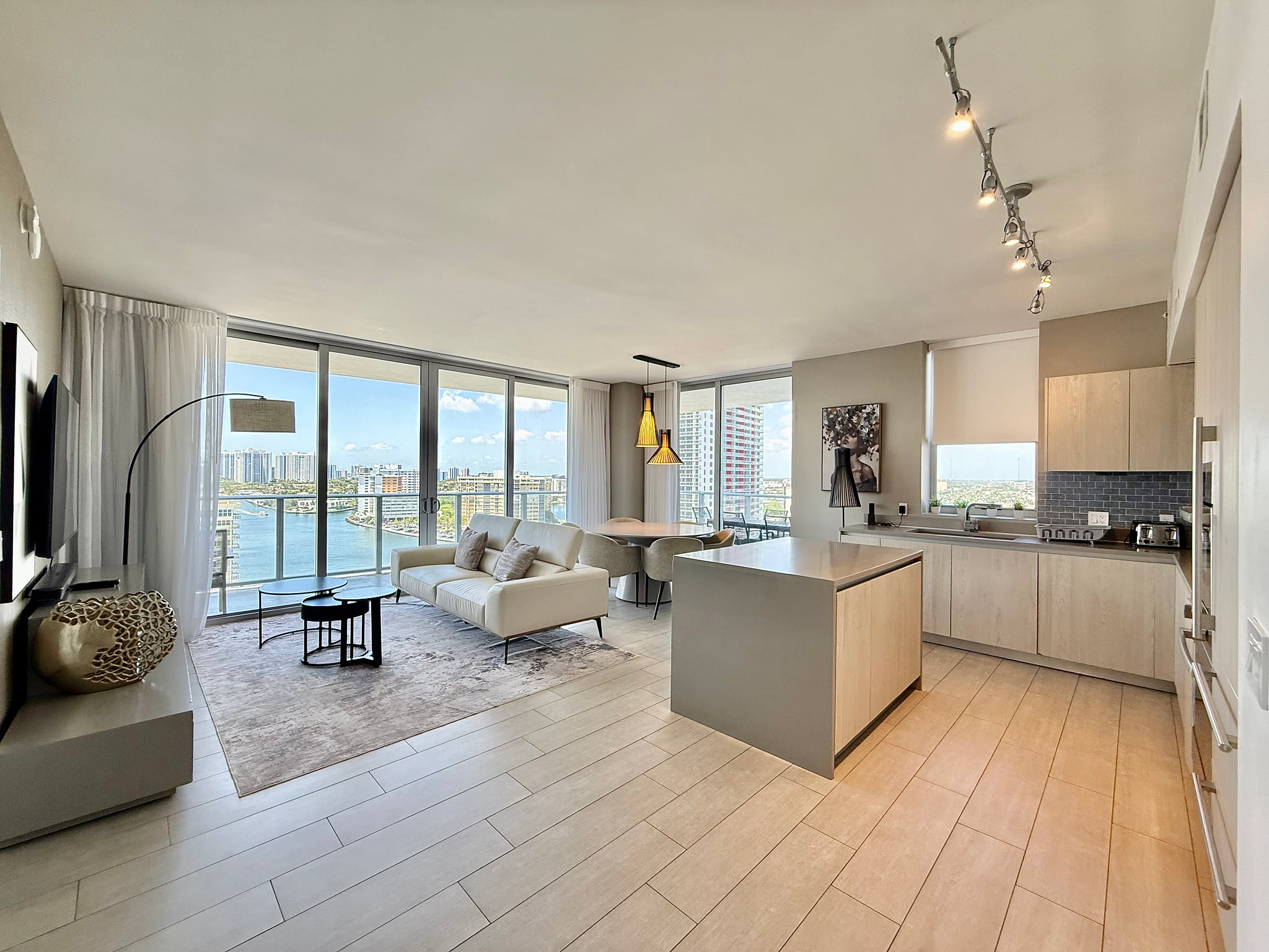 Sunlit waterfront condo with sleek kitchen, balcony & skyline views