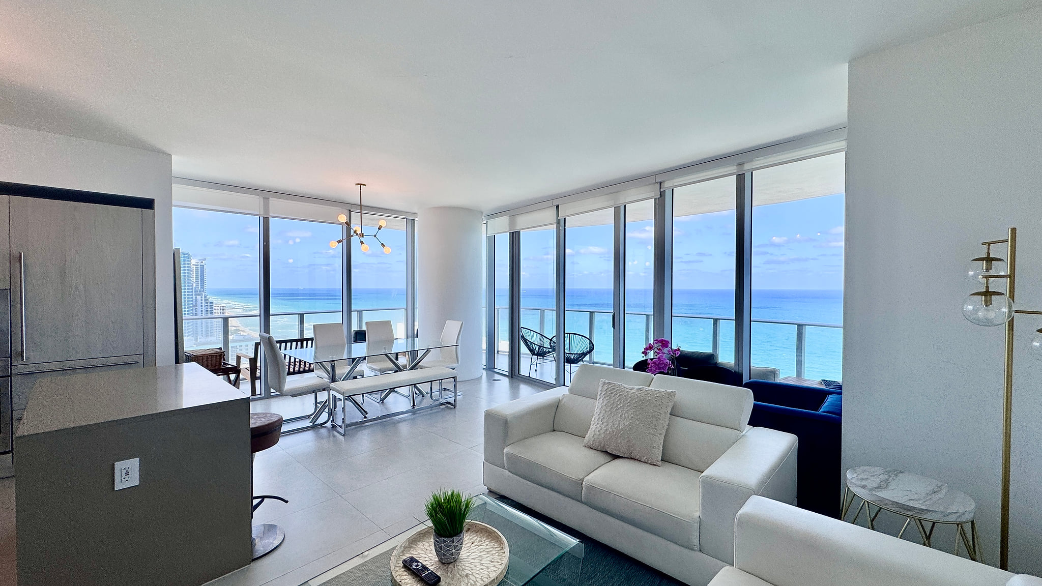 Sunlit oceanfront condo with wraparound balcony and sleek interiors