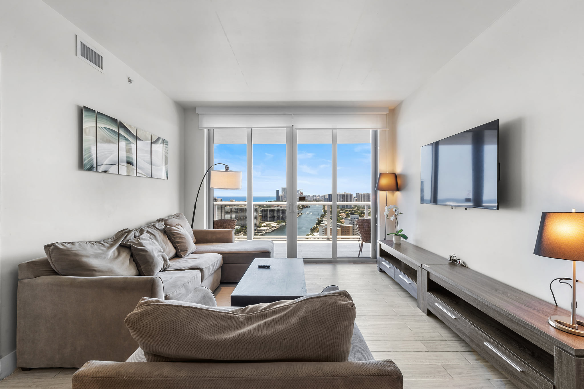 Bright living room with balcony and sweeping bay-to-ocean views