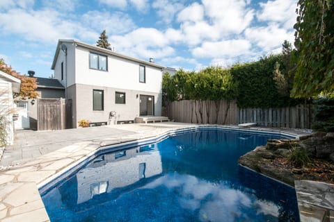 - Refreshing private pool with stone accents perfect for sunny afternoons  
- Spacious patio area designed for relaxation and gatherings  
- Outdoor retreat offering privacy with tall fenced greenery  