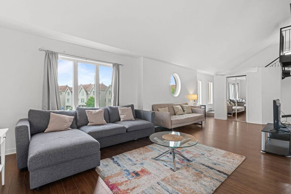 - Bright spacious living room with modern sectional sofa and natural light  
- Hardwood floors create a warm inviting atmosphere for relaxation  
- Perfect space for gathering with friends and family  
