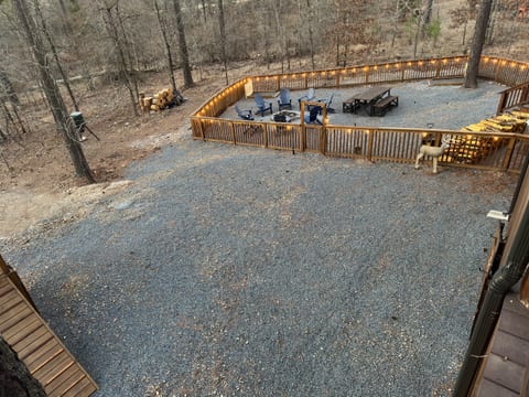 A fenced-in fire pit area nestled against the forest, where nature's embrace and crackling flames create unforgettable evenings