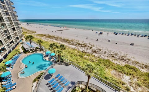 Enjoy direct beach access and stunning views from the upper-level pool deck, overlooking the coastline and turquoise waters.