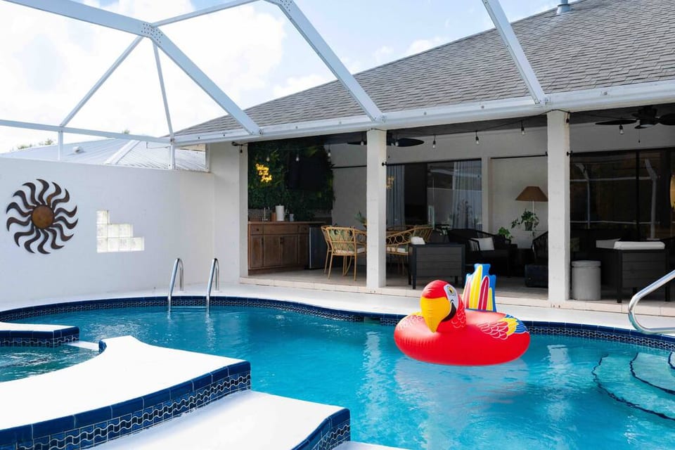 Lanai and pool area with plenty of outdoor seating, outdoor kitchen, and firepit.