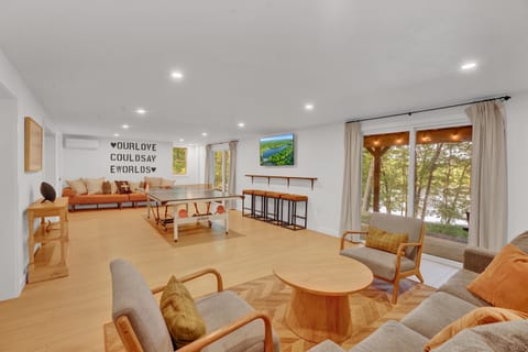 Modern entertainment room with a professional ping pong table, cozy seating, and the best lake views—perfect for fun and relaxation!