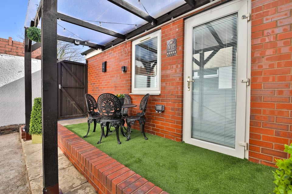 Our patio area under a pergola with a table and chairs