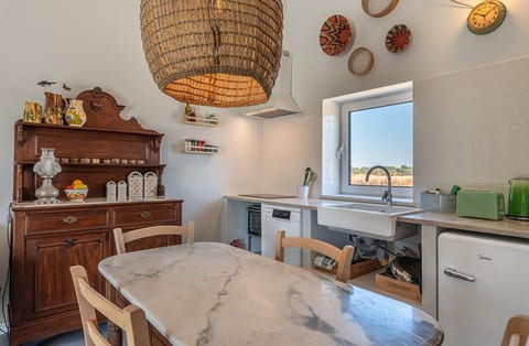 A warm and practical dining space, blending natural wood and marble with a relaxed open-plan flow into the kitchen and living room.