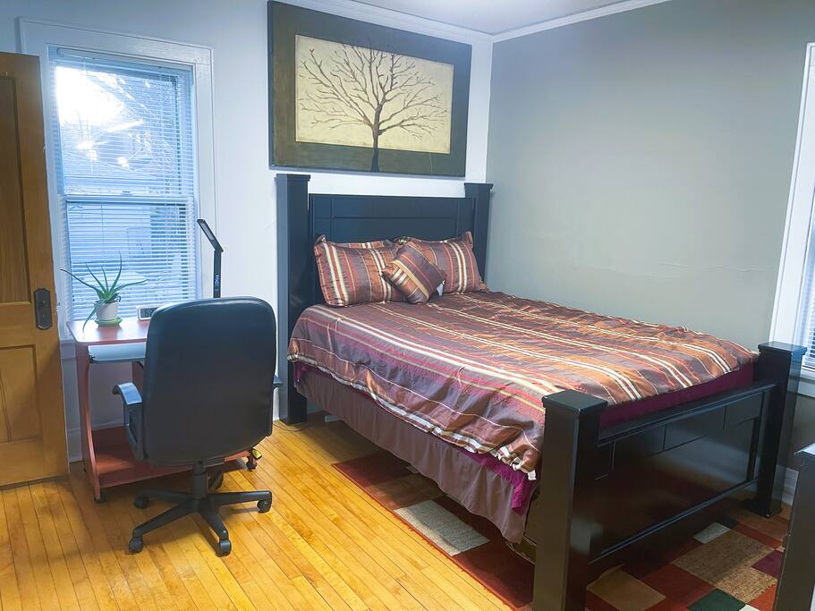 Guest Bedroom with computer table, chair, alarm clock, table lamp (with phone charger on the base; place phone on the base of the lamp to charge).